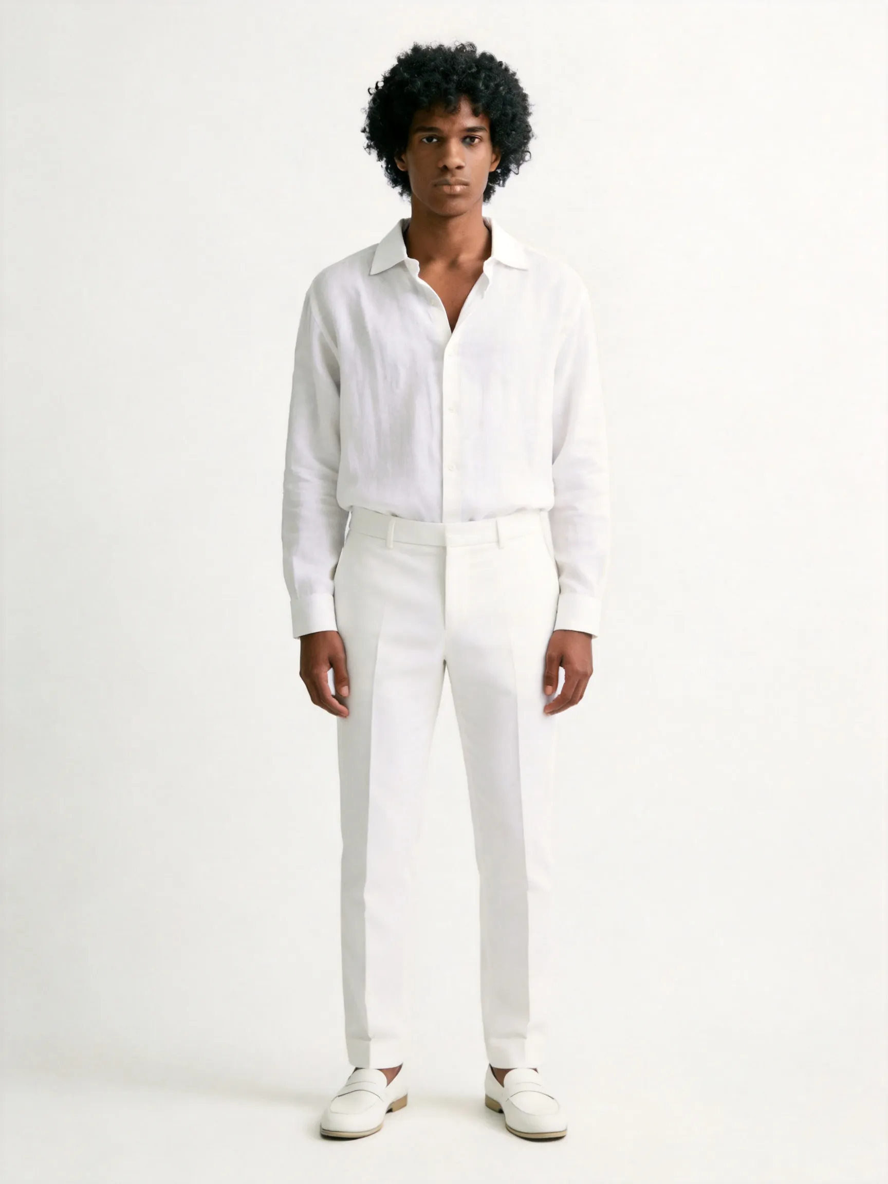 Full body shot of the man from the reference image, standing in a natural, casual and elegant full-length posture. He features his distinctive voluminous curly afro hair and calm facial features. He is wearing a sophisticated all-white monochromatic ensemble: a premium casual white linen shirt with an open collar, paired with matching well-tailored white trousers and clean white minimalist leather shoes, maintaining a high-end, clean, and minimalist luxury aesthetic. The background is a plain, seamless studio backdrop in a soft off-white/cream hue with gentle diffused lighting, keeping the environment and muted color tone completely consistent with the reference image. High-end fashion editorial photography style, sharp focus, 8k resolution, photorealistic --ar 3:4 --v 6.0