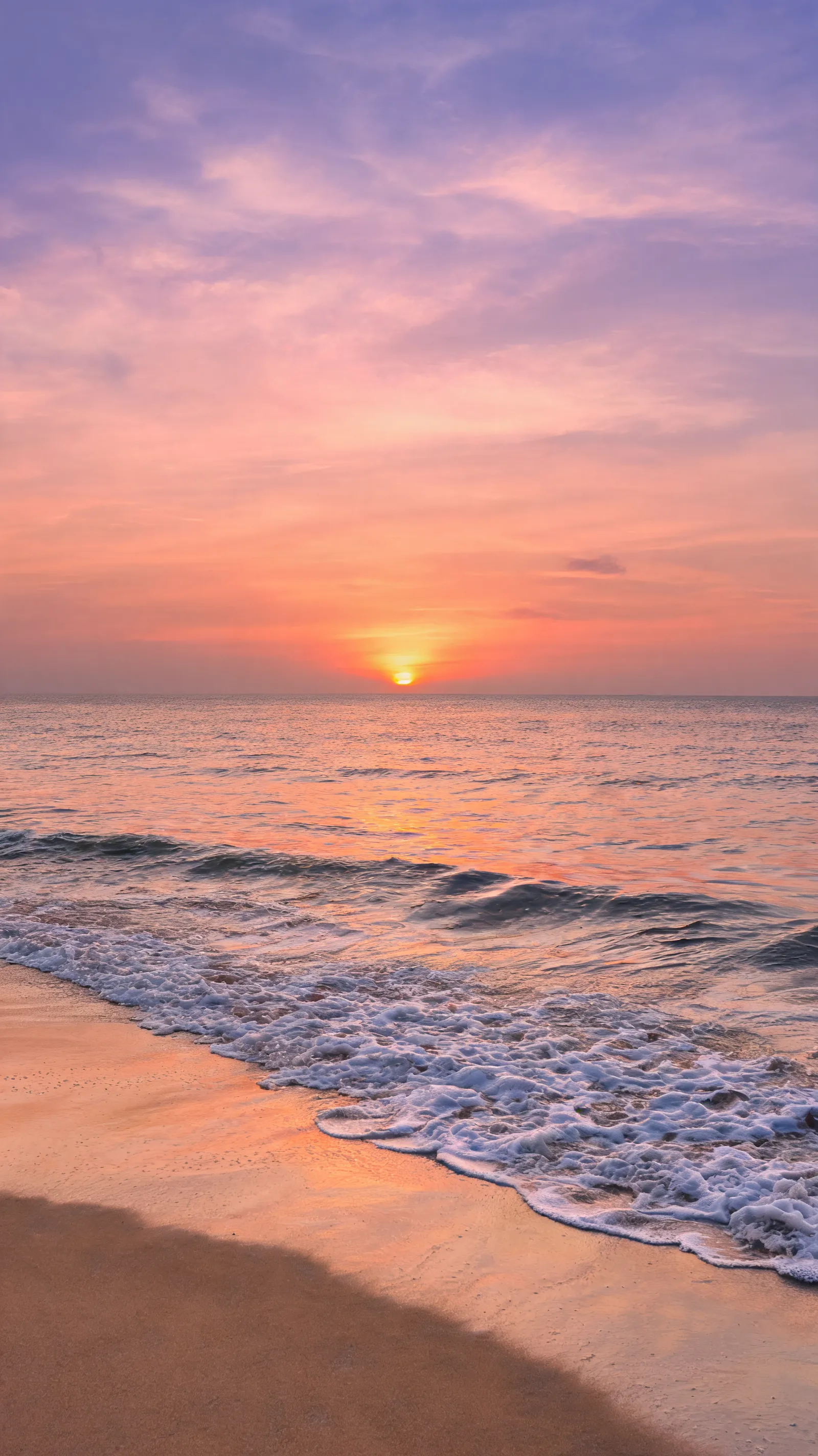 Generate a serene beach scene at sunset, with waves gently lapping at the shore.