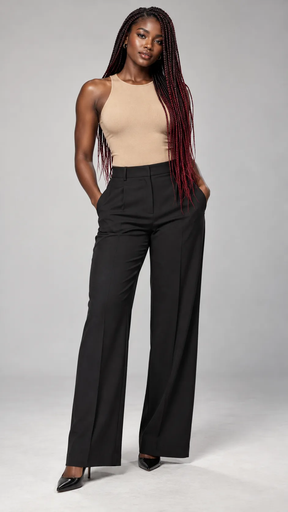 Create a photorealistic full-body commercial fashion portrait of a 28-year-old Senegalese woman, approximately 173 cm tall, with a lean athletic figure, deep ebony-brown skin, dark expressive eyes, and long micro-braids in a subtle black-to-burgundy color blend. She wears a fitted sand-colored sleeveless top, tailored black wide-leg trousers, small gold hoop earrings, and elegant black heels. Her stance is poised yet natural, with relaxed shoulders and balanced weight distribution. Preserve rich skin tones, realistic highlights, individual braid details, and authentic facial structure. Soft diffused studio lighting, pale neutral-gray seamless background, realistic textile folds, gentle floor shadows, luxury international fashion campaign photography, accurate human anatomy, head-to-toe composition with both shoes visible, vertical 9:16. No text, no watermark, no distorted hands.